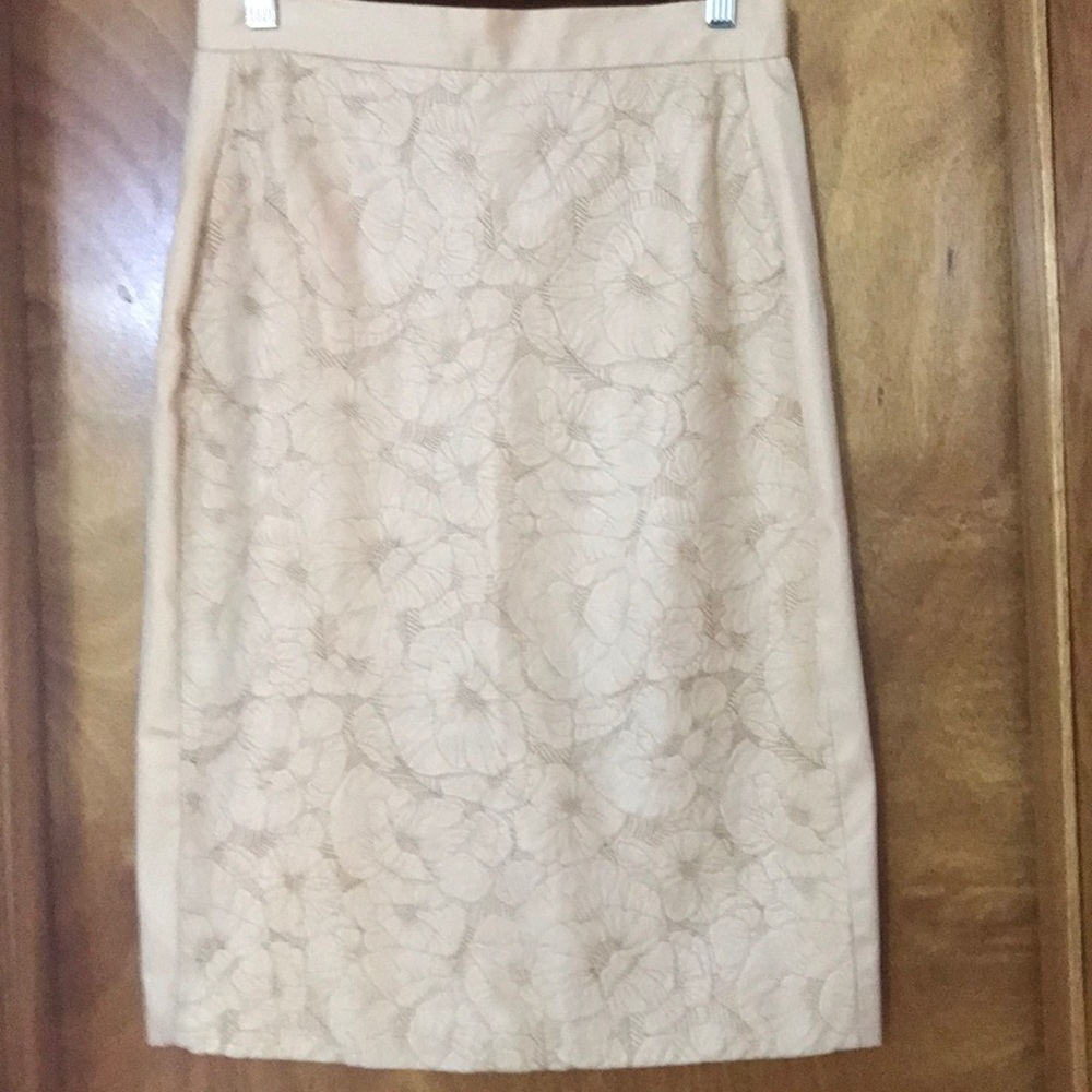 Cream colored knee length satin skirt.